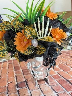 Hand Crafted Silver Skull Vase with Orange, Black and Green Faux Floral Mix